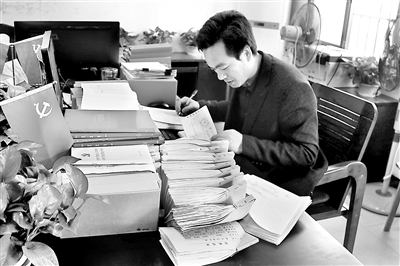 圖為熊立有在核查相關(guān)賬目。 周林 攝