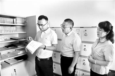 圖為李明（左）正在某企業(yè)調(diào)查取證。 王衡 攝